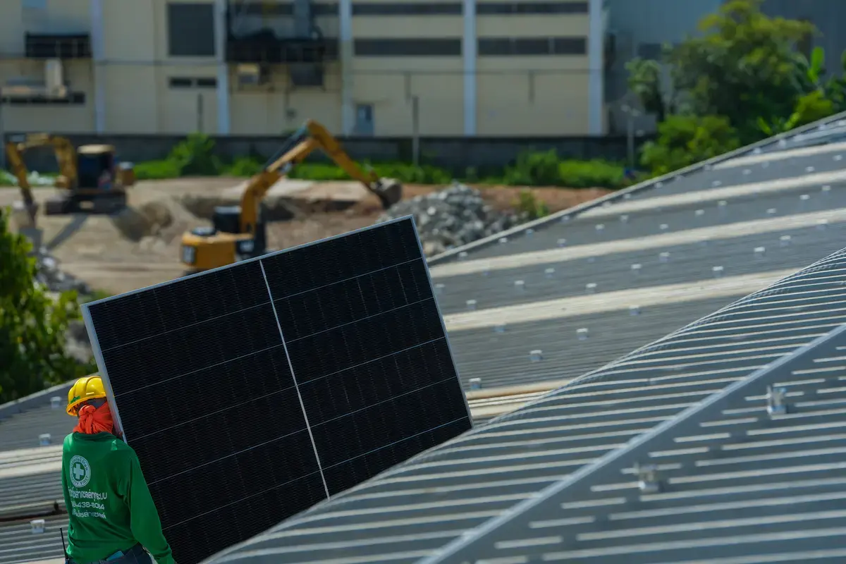 Técnico trasladando un panel solar para una instalación con batería de acumulación en Linares
